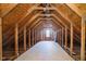 Unfinished attic space with exposed wooden beams, and a window providing natural light at 4615 Crystal Lake Dr, Indianapolis, IN 46240