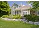 Beautiful backyard with a stone retaining wall, lush landscaping, and a screened in porch at 4615 Crystal Lake Dr, Indianapolis, IN 46240