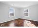 Empty bedroom with hardwood floors, neutral paint and two windows providing natural light at 4704 Blue Marlin Way, Indianapolis, IN 46239