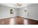 This bedroom has hardwood floors, two windows, and a modern ceiling fan at 4704 Blue Marlin Way, Indianapolis, IN 46239