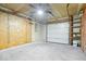 View of a spacious garage with concrete floors, plywood walls, and a shelving unit at 4704 Blue Marlin Way, Indianapolis, IN 46239