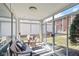 Bright sunroom with a loveseat, chair, and floor-to-ceiling windows that offer expansive views at 5034 Allisonville Rd # A, Indianapolis, IN 46205