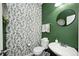 Stylish half bathroom with green walls and floral wallpaper, featuring modern fixtures and a round mirror at 5524 Goodwin St, Indianapolis, IN 46234