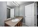 Bathroom featuring a vanity with sink, a large mirror with lights, and a white door to the side at 5524 Goodwin St, Indianapolis, IN 46234