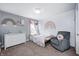 This bedroom features a rainbow theme and a cozy gray armchair with donut pillow at 5524 Goodwin St, Indianapolis, IN 46234