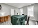 A dining room with grey walls and floors, featuring a table with a dark green tablecloth, and natural light at 5524 Goodwin St, Indianapolis, IN 46234