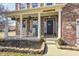 Charming brick home with a welcoming front porch featuring white columns, rocking chairs, and a 