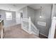 Bright hallway featuring white railings and a carpeted staircase, illuminated by modern pendant lighting at 5524 Goodwin St, Indianapolis, IN 46234