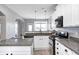 Well-appointed kitchen featuring granite countertops, stainless steel appliances, white cabinetry and hardwood floors at 5524 Goodwin St, Indianapolis, IN 46234