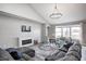 Cozy living room featuring a fireplace, plush seating, a modern chandelier and lots of natural light at 5524 Goodwin St, Indianapolis, IN 46234