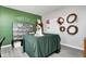 Bright room featuring a green accent wall, a table with a green tablecloth, and decor with floral and wreath themes at 5524 Goodwin St, Indianapolis, IN 46234