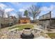 Private backyard featuring a fire pit, lush landscaping, and a storage shed at 5529 W 29Th Pl, Indianapolis, IN 46224