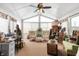 Bright sunroom with ceiling fan, neutral carpet, and an assortment of furniture and decorative objects at 5529 W 29Th Pl, Indianapolis, IN 46224