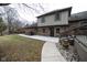 Brick home's backyard featuring a concrete patio and landscaping, accessed by a side walkway and deck steps at 5704 Springhollow Ct, Avon, IN 46123