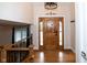 Bright foyer features hardwood floors, a statement light fixture, and a beautifully crafted wooden door at 5704 Springhollow Ct, Avon, IN 46123