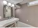 Charming bathroom with a unique sink, chrome fixtures, updated mirror, and decorative hexagon tile flooring at 6009 N Washington Blvd, Indianapolis, IN 46220