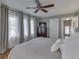 Spacious bedroom featuring a ceiling fan, hardwood floors, large windows, and neutral-toned decor at 6009 N Washington Blvd, Indianapolis, IN 46220