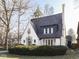 Charming home with a beautiful slate roof, arched doorway, and manicured landscaping creating curb appeal at 6009 N Washington Blvd, Indianapolis, IN 46220