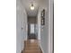 Inviting hallway with hardwood floors and white trim leads to the staircase and features decorative wall art at 6009 N Washington Blvd, Indianapolis, IN 46220