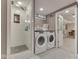 Updated laundry room with a glass shower, a washer and dryer, and neutral decor for convenient chores at 6009 N Washington Blvd, Indianapolis, IN 46220