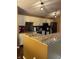 Kitchen with granite counters, updated cabinets, black appliances, and modern lighting fixtures at 6526 Jade Stream Ct # 309, Indianapolis, IN 46237