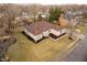 An aerial shot showcases a well-manicured brick home with a lush lawn and neatly arranged landscaping at 6528 Hedback Dr, Indianapolis, IN 46220
