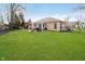 Expansive backyard with lush green grass, patio seating area, and well-maintained landscaping at 6528 Hedback Dr, Indianapolis, IN 46220