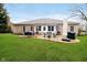 Backyard view of the brick home and the patio with seating and a grill at 6528 Hedback Dr, Indianapolis, IN 46220