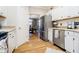 Kitchen showcasing stainless steel appliances and white cabinetry; adjacent dining area visible at 6528 Hedback Dr, Indianapolis, IN 46220