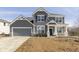 Charming two-story home with gray siding, stone accents, attached two car garage, and well-manicured front yard at 7181 Barrett Dr, Brownsburg, IN 46112