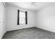 Neutral bedroom with gray carpet, a window with curtains, and a white door at 7463 Pebblebrooke W Dr, Indianapolis, IN 46236
