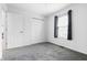 Neutral bedroom with gray carpet, a window with curtains, and a double door closet at 7463 Pebblebrooke W Dr, Indianapolis, IN 46236