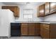 Practical kitchen featuring wood cabinets, tile flooring, and modern appliances at 7463 Pebblebrooke W Dr, Indianapolis, IN 46236
