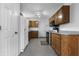 Functional kitchen with wood cabinets, modern appliances, and tile flooring at 7463 Pebblebrooke W Dr, Indianapolis, IN 46236