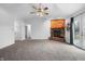 Open living room featuring a brick fireplace, plush carpet, and access to the backyard at 7463 Pebblebrooke W Dr, Indianapolis, IN 46236