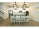 Modern kitchen boasts stainless appliances, white cabinetry, a sleek black countertop island and pendant lighting at 761 Stone Trace Ct, Avon, IN 46123
