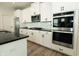 Well-equipped kitchen featuring stainless steel appliances, white cabinets, and a black countertop at 761 Stone Trace Ct, Avon, IN 46123