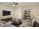 Staged living room with tv, shelving, coffee table, gray sofa and arm chairs, and neutral rug at 761 Stone Trace Ct, Avon, IN 46123
