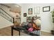 Well-lit home office with a black desk, shelving, and stairs, showcasing a functional and organized workspace at 761 Stone Trace Ct, Avon, IN 46123