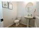 Powder room featuring hardwood flooring, pedestal sink, round mirror and neutral paint at 761 Stone Trace Ct, Avon, IN 46123
