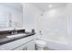 Pristine bathroom featuring a shower-tub combination, white cabinets, and a sleek countertop at 7658 Hillway Dr, Indianapolis, IN 46113