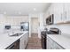 Modern kitchen with stainless steel appliances, quartz countertops, and sleek white cabinetry, designed for culinary enthusiasts at 7658 Hillway Dr, Indianapolis, IN 46113