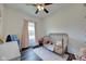 Bright bedroom featuring a crib, hardwood floors, and closet with various clothes at 7859 Moore Rd, Gosport, IN 47433