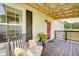 Relaxing front porch with comfortable seating, a wooden deck, and a charming red door at 7859 Moore Rd, Gosport, IN 47433