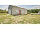 Exterior of detached garage featuring a red door and wooded surroundings at 7859 Moore Rd, Gosport, IN 47433