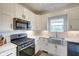 Well-lit kitchen with white cabinetry, marble counters, stainless steel appliances, and a modern gas range at 7859 Moore Rd, Gosport, IN 47433