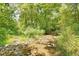 A beautiful landscape with a rocky creek bed, lush trees and greenery at 7859 Moore Rd, Gosport, IN 47433