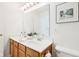 Bright bathroom featuring a double sink vanity with a large mirror and oak cabinetry at 8074 Carina Dr, Indianapolis, IN 46268