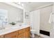 Bright bathroom featuring a double sink vanity, framed mirror, and shower with white curtain at 8074 Carina Dr, Indianapolis, IN 46268