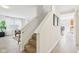 Hallway with hardwood floors, stairs, and an open sightline to a naturally lit living room at 8074 Carina Dr, Indianapolis, IN 46268